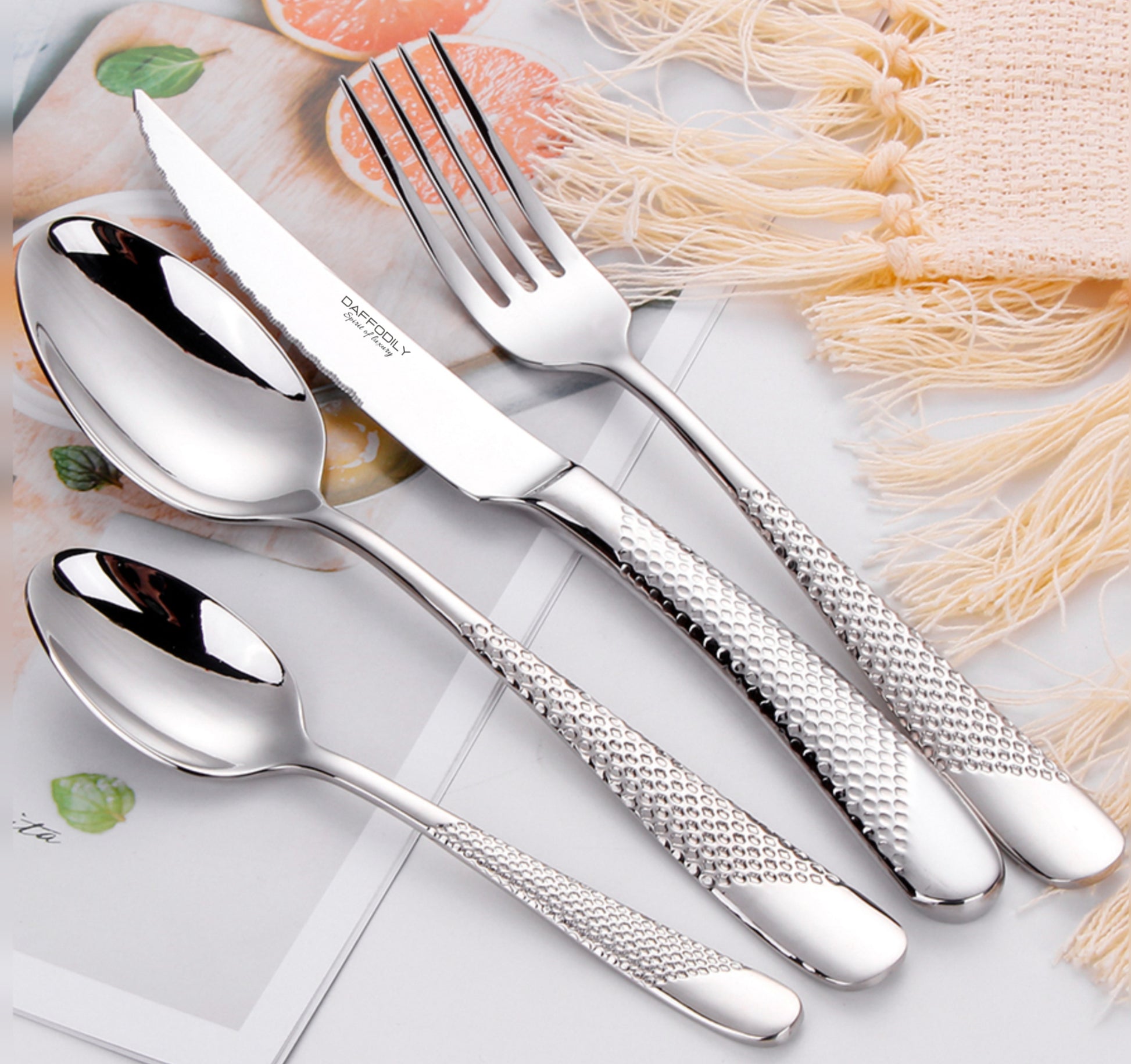 Signature luxury cutlery set with textured handles, 18/10 stainless steel silver flatware on soft cloth background